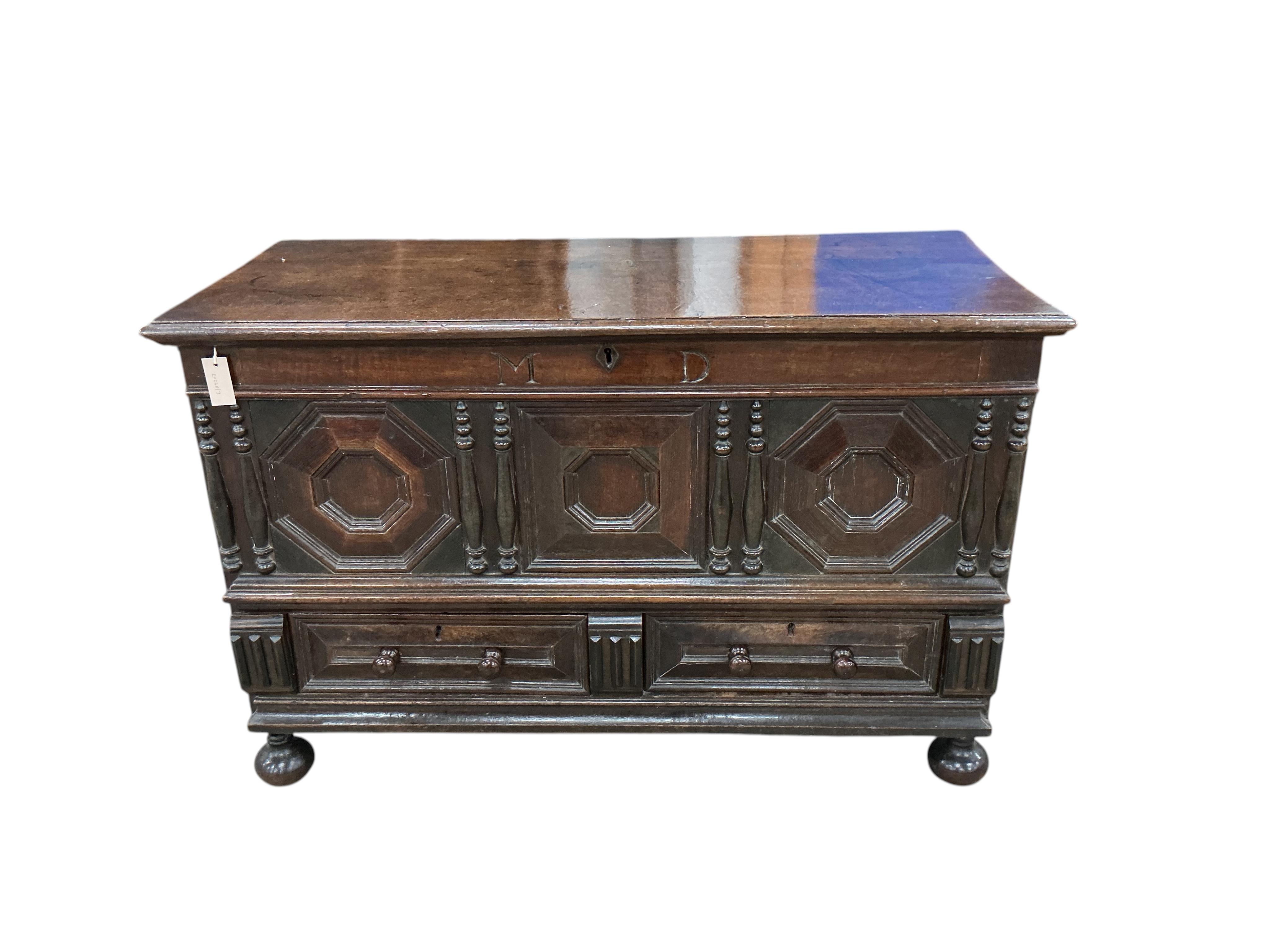 An 18th century panelled oak mule chest, carved with the initials M D, width 129cm, depth 57cm, height 83cm